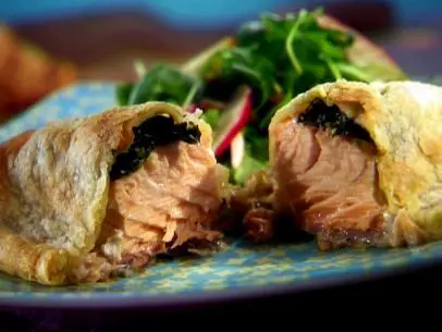 A piece of salmon pie is sliced on the plate.