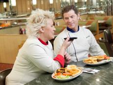 Chefs Anne Burrell and Bobby Flay contacting their recruits by phone from the Tick-Tock Diner, as seen on Food Network’s Worst Cooks in America, Season 3.