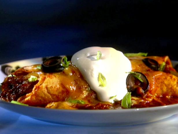 A plate of holla beef enchiladas made with shredded beef and cheeses and smothered with a homemade three chili enchilada sauce.