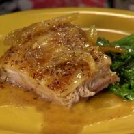 A sliced of crispy mustard braised pork belly is served.