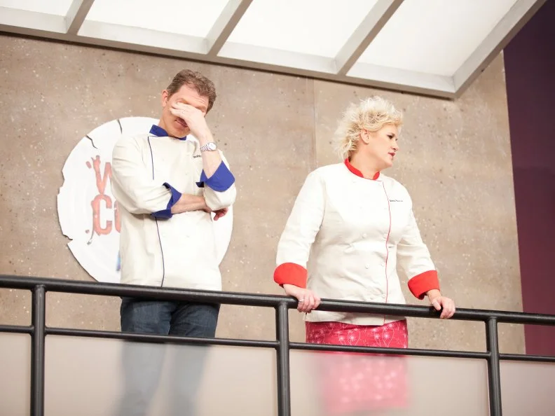 Chefs Bobby Flay and Anne Burrell observe the Red Team and Blue team cooking for the Everything Seafood challenge as seen on Food Network's Worst Cooks in America, Season 3.