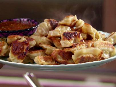 A plate of easy to make shrimp potstickers with a sauce to dip them in