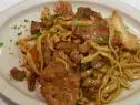 Veal and chicken pasta is served with mushrooms and parsley.