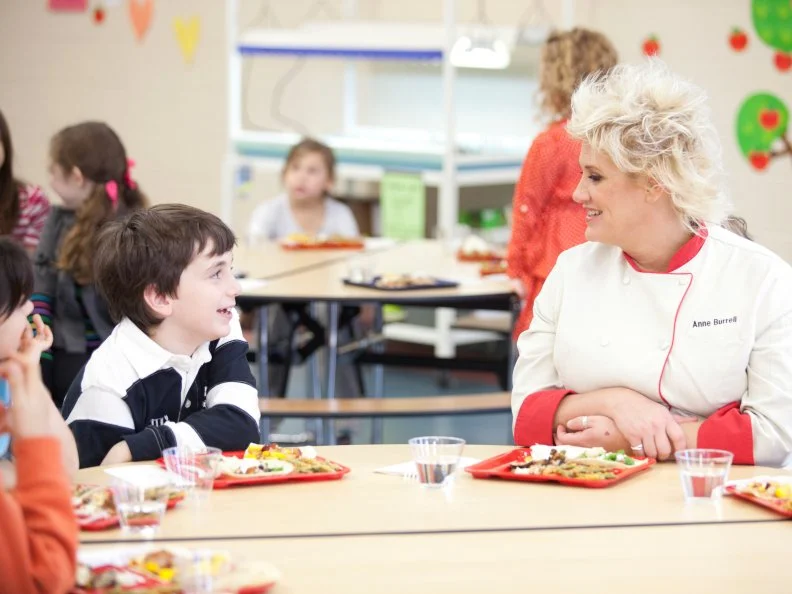 Chef Anne Burrell and elementary school students taste the healthy and kid-friendly cafeteria food made by the recruits in the Cooking for Kids Challenge as seen on Food Network's Worst Cooks in America, Season 3.