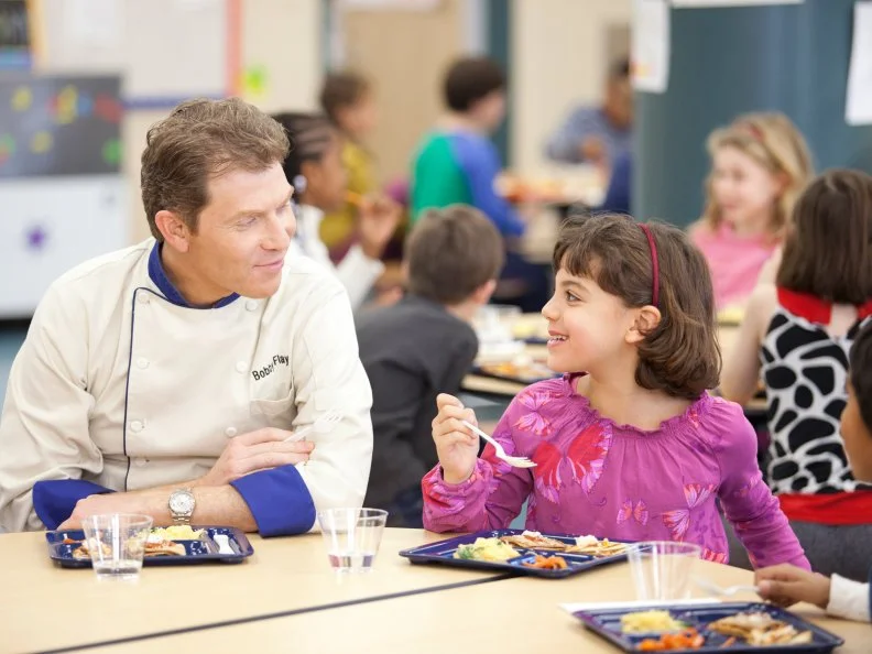 Chef Bobby Flay and elementary school students taste the healthy and kid-friendly cafeteria food made by the recruits in the Cooking for Kids Challenge as seen on Food Network's Worst Cooks in America, Season 3.