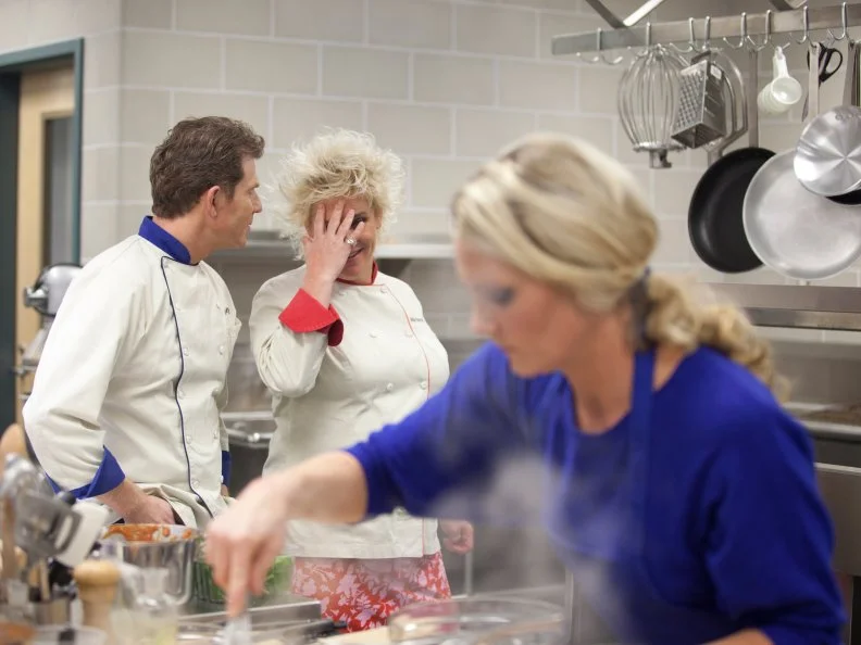 During the Cooking for Kids Challenge, Chefs Bobby Flay and Anne Burrell observe Melissa Rhodes as she prepares a healthy and kid-friendly cafeteria meal for students at an elementary school as seen on Food Network's Worst Cooks in America, Season 3.