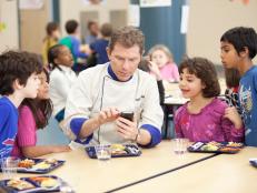 Chef Bobby Flay and elementary school students taste the healthy and kid-friendly cafeteria food made by the recruits in the Cooking for Kids Challenge as seen on Food Network's Worst Cooks in America, Season 3.
