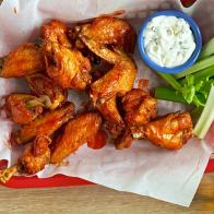 The wings are tossed in hot sauce.