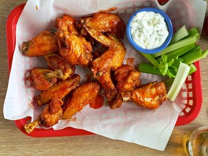 The wings are tossed in hot sauce.