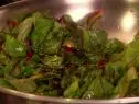 Garlicky Sautéed Swiss Chard is tossed in a stainless steel bowl.