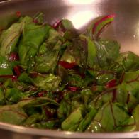 Garlicky Sautéed Swiss Chard is tossed in a stainless steel bowl.