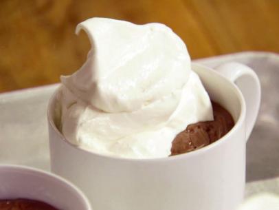 Chocolate pudding is topped with whip topping.