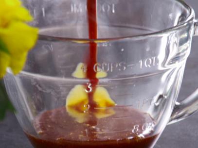 Caramel sauce is poured into a glass measuring cup.