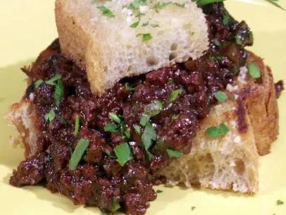 Close up of sloppy joe sandwich on a yellow plate.