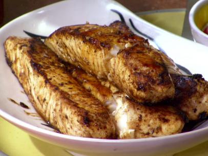 The grilled fish is placed in a serving bowl.