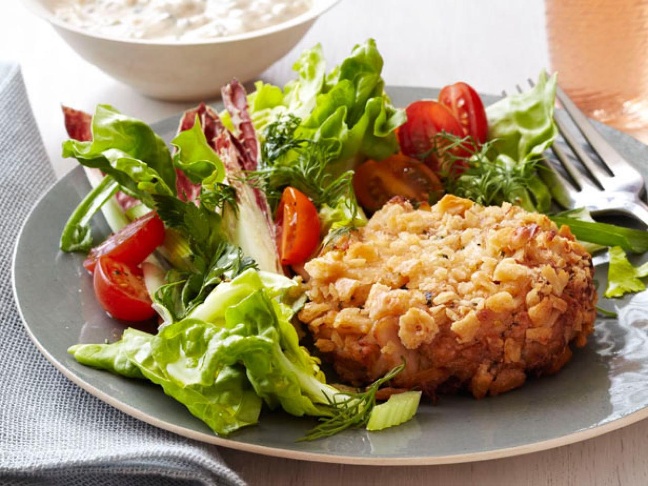 Fish cakes and salad on a plate isolated against white Stock Photo - Alamy