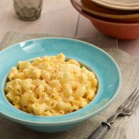 Slow cooker macaroni cheese served in a blue bowl.