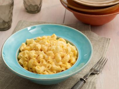 Slow cooker macaroni cheese served in a blue bowl.