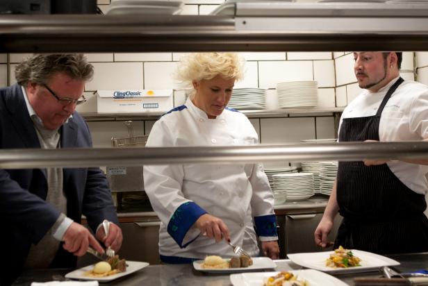 Anne Burrell and David Burke sample dark meat and liver sausage prepared by Chef Phil Definna, right, in the kitchen of Fromagerie as seen on Food Network’s The Anne Burrell Project, Season 1.