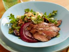 Flank steak gets coated with a flavorful garlic-vinegar marinade before hitting the grill alongside crunchy red onion slices. A hearty salad made with bulgur, arugula and fresh herbs rounds it all out.