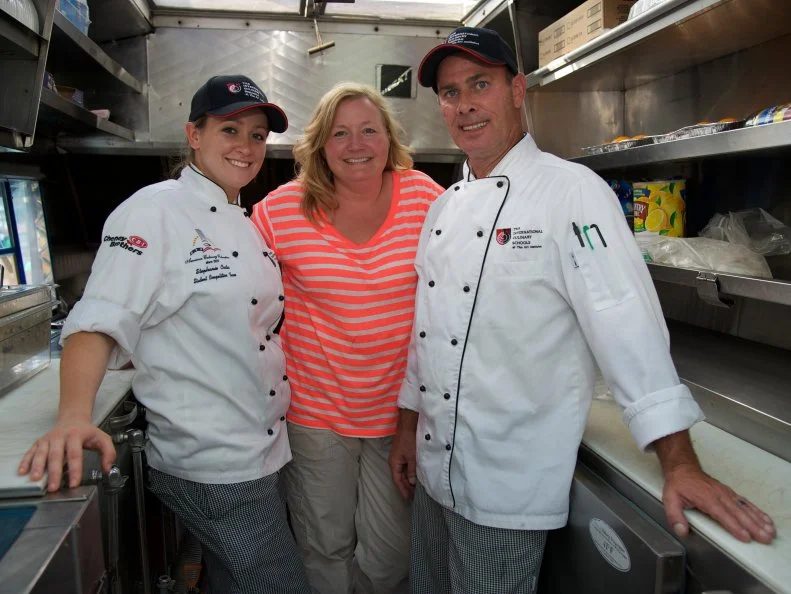 Taking a much needed break, Angela Reynolds and her culinary students from Nashville's Art Institutes pose in the Momma's Grizzly Grub food truck kitchen. Watch the teams compete on Food Network's The Great Food Truck Race, Season 3.