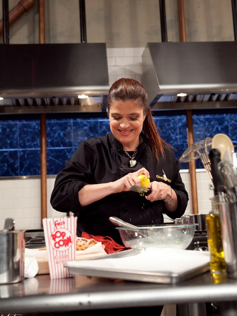 Chef Alex Guarnaschelli working on her dessert that must include: popcorn, sour cream, funnel cake and a blue snow cone, as seen on Food Network's Chopped: After Hours.