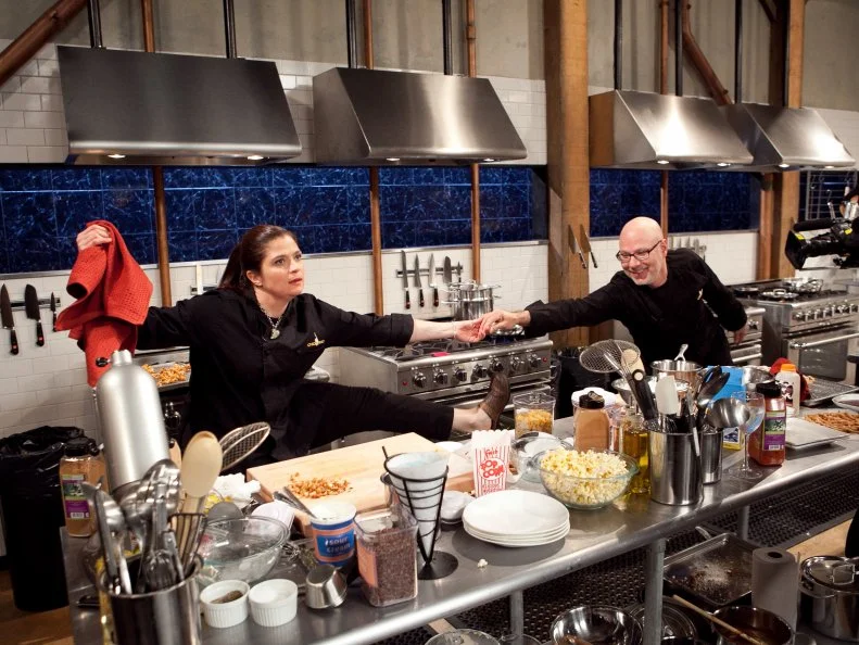 After Hours Chef Ron Ben-Israel asks Chef Alex to stretch out and dance with him instead of working on her dessert that must include: Popcorn, sour cream, funnel cake and blue snow cone ,as seen on Food Network's Chopped After Hours, as seen on Food Network's Chopped: After Hours.