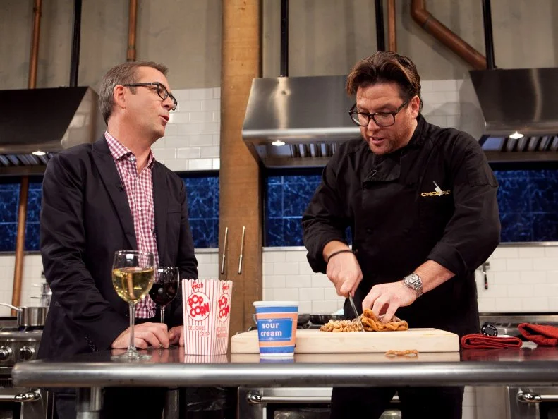 Chopped: After Hours host Ted Allen checks in with chef Scott Conant while he works on his dessert that must include: popcorn, sour cream, funnel cake and a blue snow cone, as seen on Food Network's Chopped: After Hours.