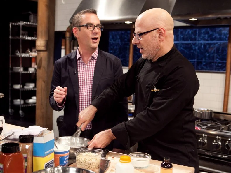 After Hours host Ted Allen teasing Chef Ron Ben-Israel moments after the chef burnt his snow cone reduction, making Chef Ron Ben-Israel the first person known to have burned a snow cone on tv, as seen on Food Network's Chopped: After Hours.