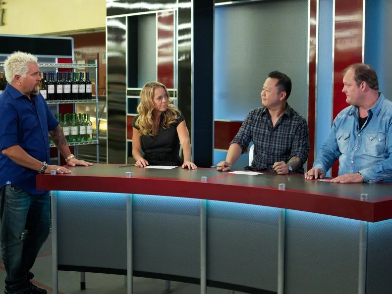 Host Guy Fieri with judges Melissa D'Arabian, Jet Tila, and Beau MacMillan, during the judging portion of Game 1, 5 Ingredients Or Less, Asian Stir Fry, as seen on Food Network's Guy's Grocery Games, Season 1.