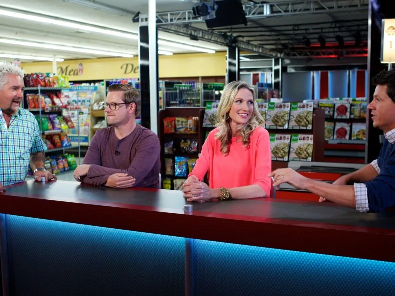 Host Guy Fieri with judges Richard Blais, Catherine McCord, and Troy Johnson during the cooking part of Game 1, Out of Stock, Gourmet Salad, All Leafy Greens and Lettuce removed, 30 minute time limit, as seen on Food Network's Guy's Grocery Games, Season 1.