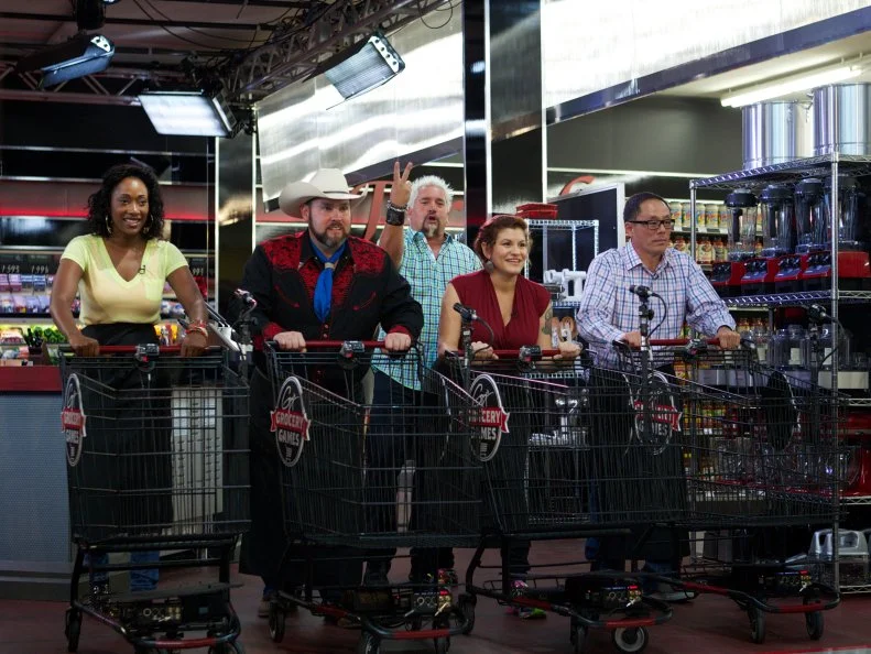 Host Guy Fieri with chefs Jessica Swift, Lenny McNad, Cristina Topham, and Greg Akahoshi during the start of the shopping part of Game 1, Out of Stock, Gourmet Salad, All Leafy Greens and Lettuce removed, 30 minute time limit, as seen on Food Network's Guy's Grocery Games, Season 1.