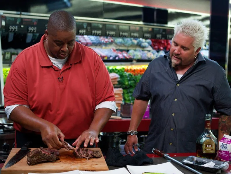 Host Guy Fieri with chef Shawn Davis during the cooking part of Game 3, Grocery List, Steakhouse Dinner, as seen on Food Network's Guy's Grocery Games, Season 1.
