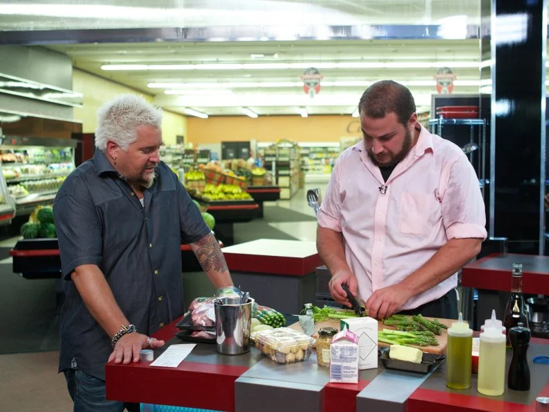 Host Guy Fieri with chef Gio Ketchedjian during the cooking part of Game 3, Grocery List, Steakhouse Dinner, as seen on Food Network's Guy's Grocery Games, Season 1.