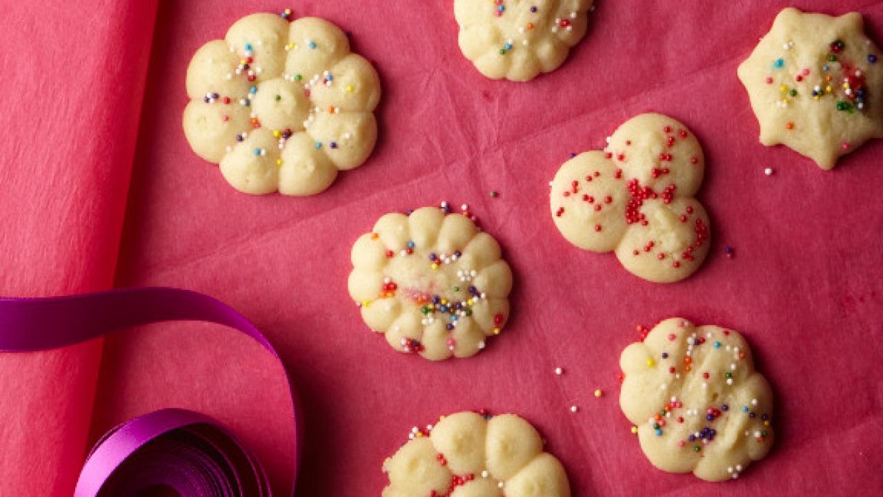 Spritz cookies on a pink background.