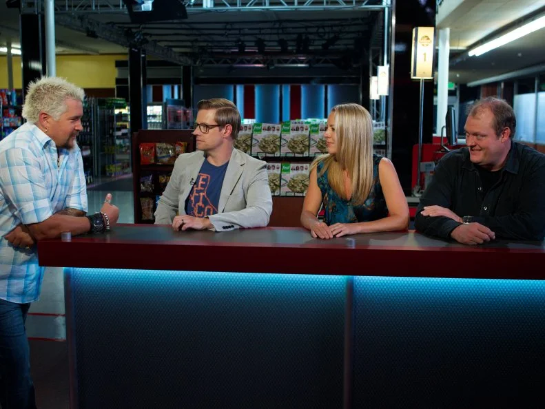 Host Guy Fieri with judges Richard Blais, Melissa D'Arabian, and Beau MacMillan during the cooking part of Game 3, Closing Time, Savory Pie, 3 min to shop and 30 min cooking time, as seen on Food Network's Guy's Grocery Games, Season 1.