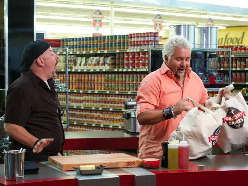 Host Guy Fieri with chef Luca Paris as he reacts to the Bag Swap during start of Game 3, Grocery Bag secretly Bag Swap after the shopping, Gourmet Lunch, 3 min to shop and 30 min cooking time, as seen on Food Network's Guy's Grocery Games, Season 1.