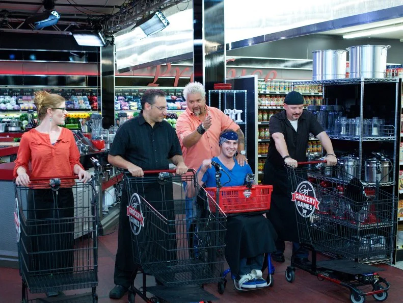 Host Guy Fieri with chefs Lori Hill, Stephan Germanaud, Chris Bales, and Luca Paris during the start of the shopping of Game 1, Grocery List, Best Egg Dish, 30 min cooking time, as seen on Food Network's Guy's Grocery Games, Season 1.