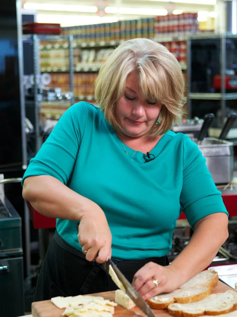 Chef Amy Barnes during the cooking part of Game 1, Budget Battle, Elevated Grilled Cheese Sandwich for 4 with $6.97, 18 coupons in play, 30 min cooking time, as seen on Food Network's Guy's Grocery Games, Season 1.
