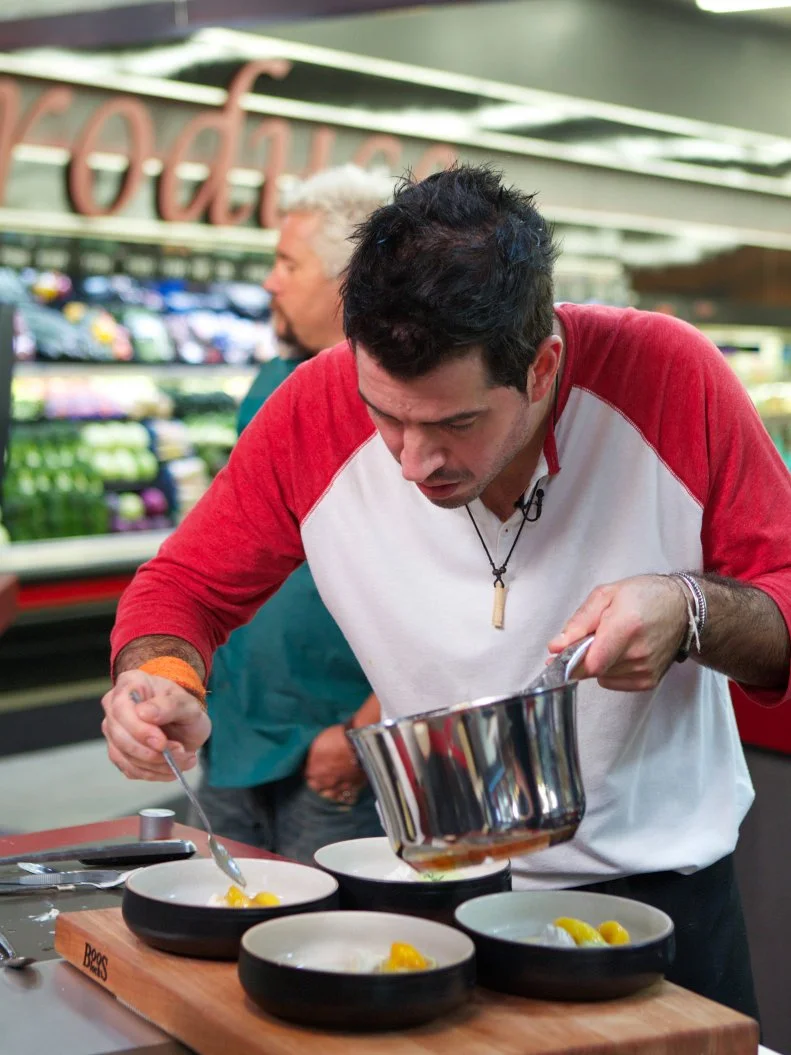 Chef Jason Febres during the cooking part of Game 2, Single Aisle Showdown, Unusual Dessert, 30 min cooking time, as seen on Food Network's Guy's Grocery Games, Season 1.