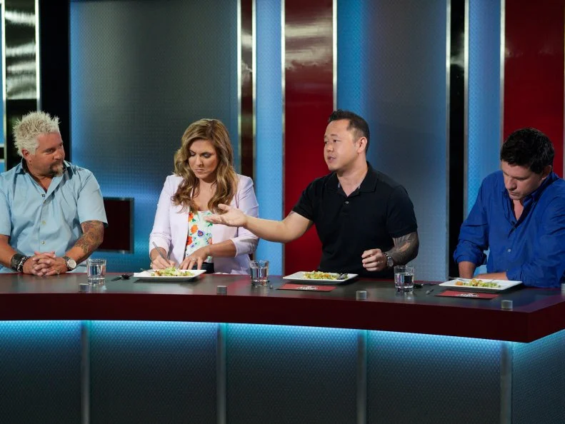 Host Guy Fieri with judges Lorena Garcia, Jet Tila, and Troy Johnson during the judging part of Game 1, Frozen Food Feud, Best Seafood Dish, freezer only and 30 minute time limit, as seen on Food Network's Guy's Grocery Games, Season 1.