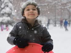Caucasian boy sledding in snow