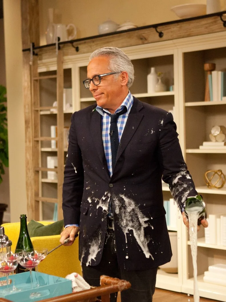 Geoffrey Zakarian reacts after a bottle of champagne exploded as he attempted to open it with a sword as seen on Food Network's The Kitchen, Season 1.