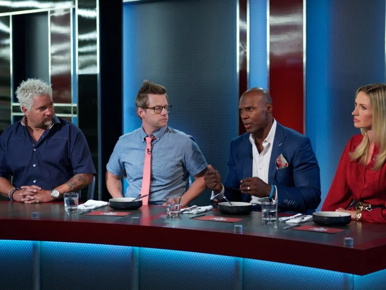 Host Guy Fieri with judges Richard Blais, DC Crenshaw, and Catherine McCord during the judging part of Game 2, Single Aisle Showdown, Best Dish, Aisle 1 only with produce and condiments, 30 min cooking time, as seen on Food Network's Guy's Grocery Games, Season 1.