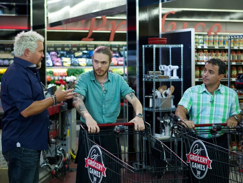 Host Guy Fieri with chefs Phillip Franklin Lee and David Aflalo during the start of the shopping part of Game 3, 5 Ingredients Or Less, Upscale Chicken Dinner, 35 min cooking time, as seen on Food Network's Guy's Grocery Games, Season 1.