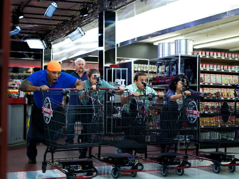 Host Guy Fieri with chefs Tal Sims, Phillip Franklin Lee, David Aflalo, Adela Jung during the start of the shopping of Game 1, Closing Time, Game Day Feast, 2 min shopping time and 30 min cooking time, as seen on Food Network's Guy's Grocery Games, Season 1.
