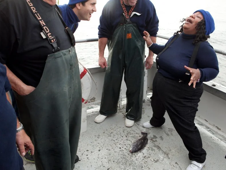 Alex Stein makes fun of Carla Johnson as she recoils from touching her fish, as seen on Food Network's Worst Cooks in America, Season 4