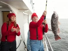 Dr. Bob Schaefer pulls his fish out of the water while Sue Mangogna cheers for him, as seen on Food Network's Worst Cooks in America, Season 4