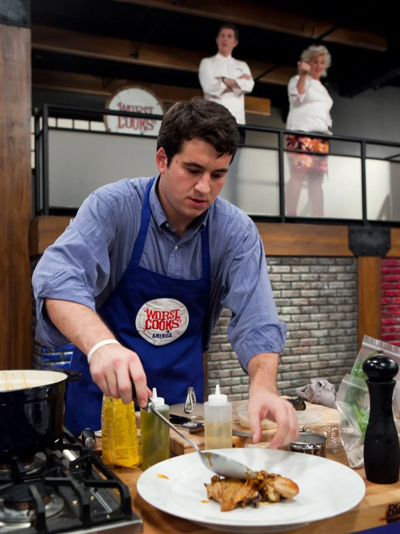 The blue teams ALex Stein plating his chicken during his attempt to recreate Chef Flay's Chicken Chasseur (Hunter-style Chicken) with Creamy Polenta with Gruyere and Parmesan, As seen on Food Networks Worst Cooks in America, season 4