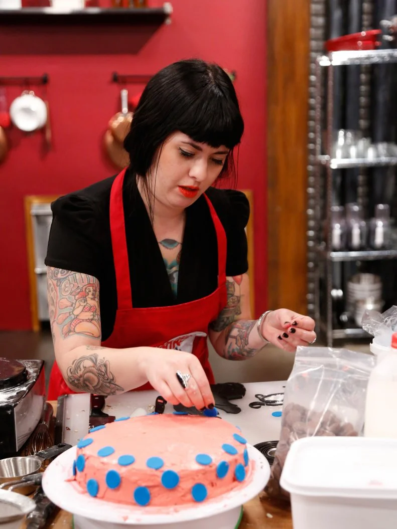 Red Team recruit Crystal Lonneberg frosting her variation of a Basic Vanilla Cake with Swiss Meringue Buttercream Frosting demonstrated by Chef Ron Ben-Israel. Chef Ron gave the recruits very specific directions to follow as a basis for their own unique cakes. Crystal is calling her cake "Winter in Paris." It's flavored with Vanilla Extract, Almonds, Chocolate, and Expresso, as seen on Food Network's Worst Cooks in America, Season 4.